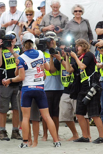 IMGP5670.jpg - In mid-February the annual Coast to Coast multisport event was held and I once again fought for a position alongside the finishing chute to watch the winning Longest Day competitors arrive.  The women's race was won by Sophie Hart, a doctor from Nelson.  She was met at the finish line by her enthusiastic partner (source of the extra hands) and a small mob of photographers.  A bit of luck in timing caught the photographer's flash.